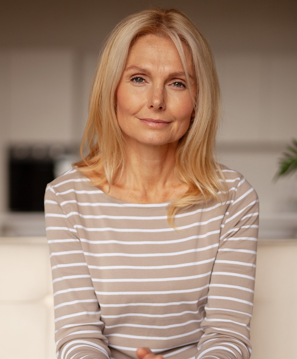 Smiling woman with blonde hair in striped top.
